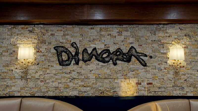 Dining room booths with Dimora printed on wall